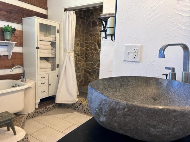 bathroom featuring tile patterned flooring, sink, and a bathing tub