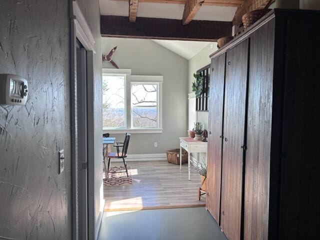 doorway to outside with vaulted ceiling with beams