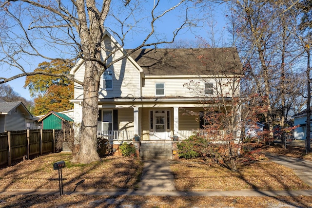 view of front of home featuring covered porch and fence