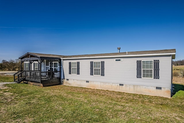 back of property featuring crawl space, a wooden deck, and a lawn