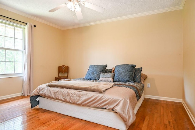 bedroom with hardwood / wood-style flooring, ceiling fan, a textured ceiling, and multiple windows