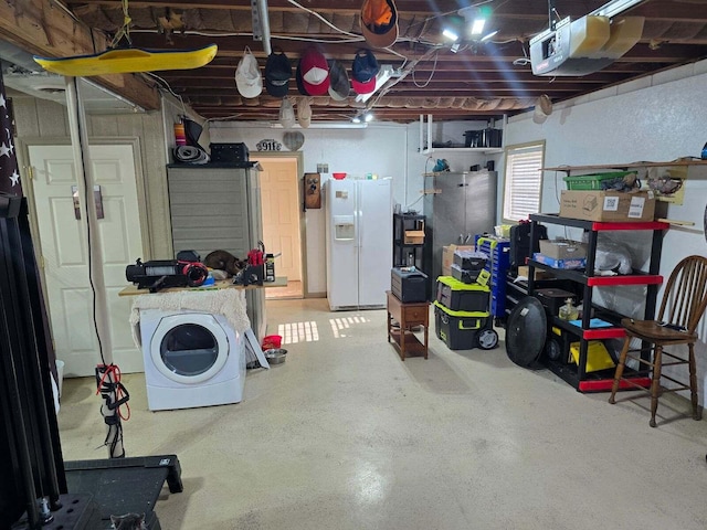 garage featuring washer / dryer and white refrigerator with ice dispenser