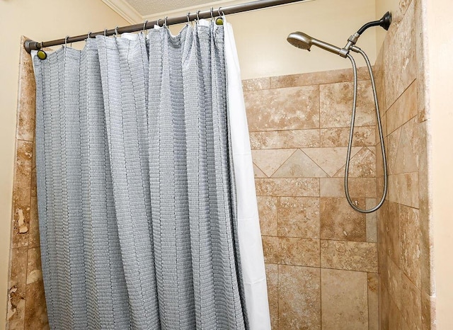 details featuring a shower with shower curtain and ornamental molding