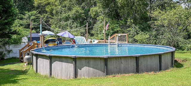 view of pool featuring a lawn