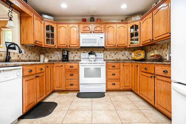 kitchen with sink, backsplash, white appliances, light tile patterned floors, and ornamental molding