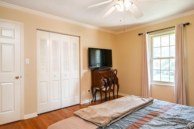 bedroom featuring ceiling fan, a closet, crown molding, and a textured ceiling