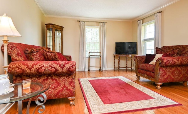 living room with hardwood / wood-style flooring, plenty of natural light, and crown molding