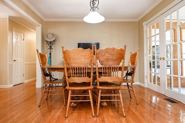 dining space featuring crown molding, french doors, and hardwood / wood-style flooring