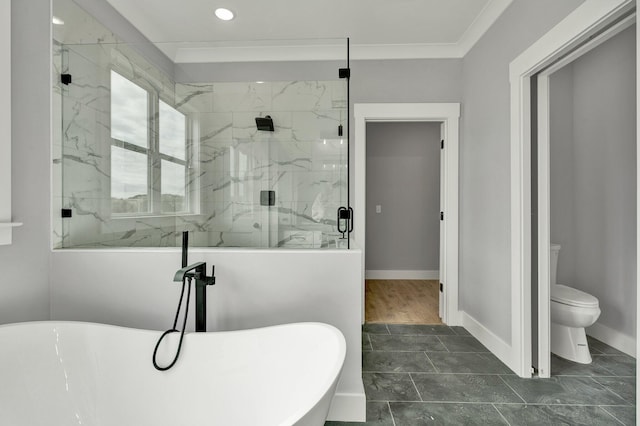 bathroom featuring crown molding, a marble finish shower, a freestanding bath, toilet, and baseboards