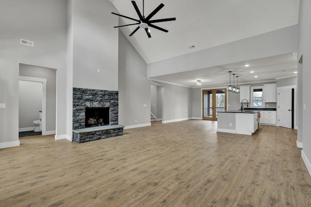 unfurnished living room featuring crown molding, visible vents, dark wood-type flooring, ceiling fan, and baseboards