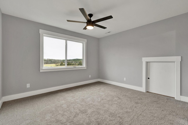 unfurnished room featuring ceiling fan, carpet floors, visible vents, and baseboards