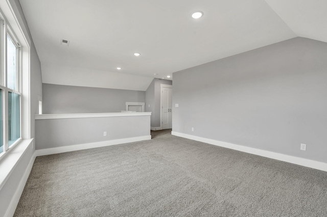 carpeted empty room with lofted ceiling, recessed lighting, visible vents, and baseboards