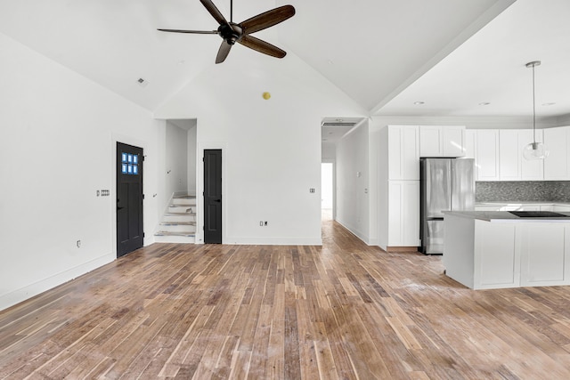 unfurnished living room featuring high vaulted ceiling, light hardwood / wood-style flooring, and ceiling fan