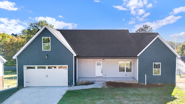 view of front of house with covered porch, a garage, and a front yard