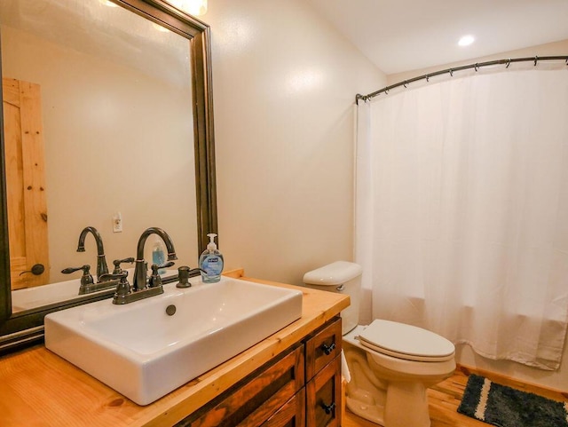 full bathroom featuring shower / bathtub combination with curtain, hardwood / wood-style floors, vanity, and toilet