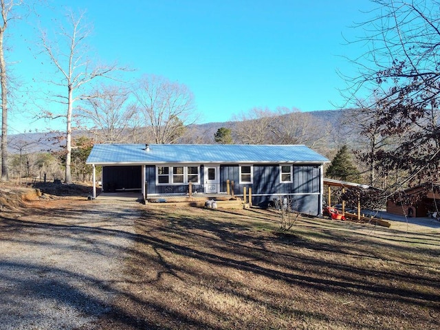 ranch-style home featuring a carport, a mountain view, and covered porch