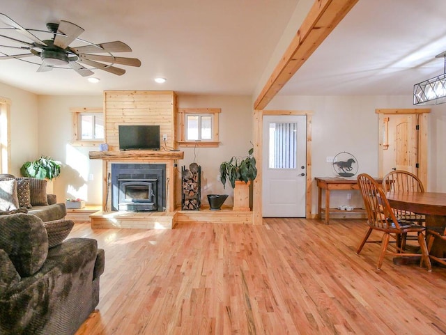 living room featuring beam ceiling, ceiling fan, and light hardwood / wood-style flooring