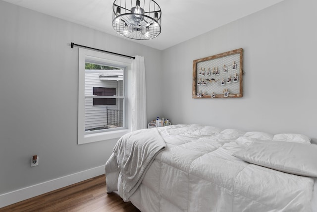 bedroom with hardwood / wood-style flooring and a chandelier