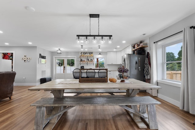 dining room with french doors, a healthy amount of sunlight, and light wood-type flooring