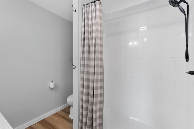 bathroom featuring wood-type flooring, toilet, and walk in shower