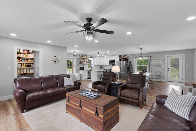 living room with ceiling fan and light hardwood / wood-style flooring