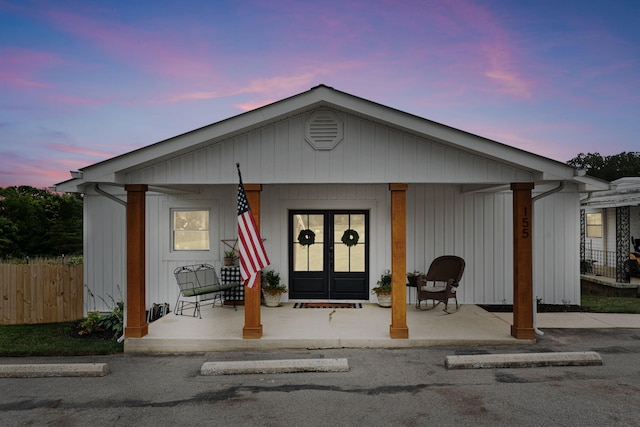 view of front of house with covered porch and french doors