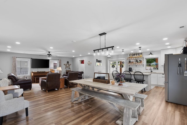 dining space with sink and light wood-type flooring