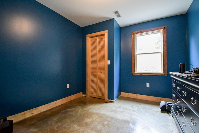 unfurnished bedroom with a closet and concrete flooring