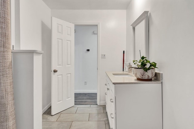 bathroom featuring baseboards, tile patterned floors, and vanity