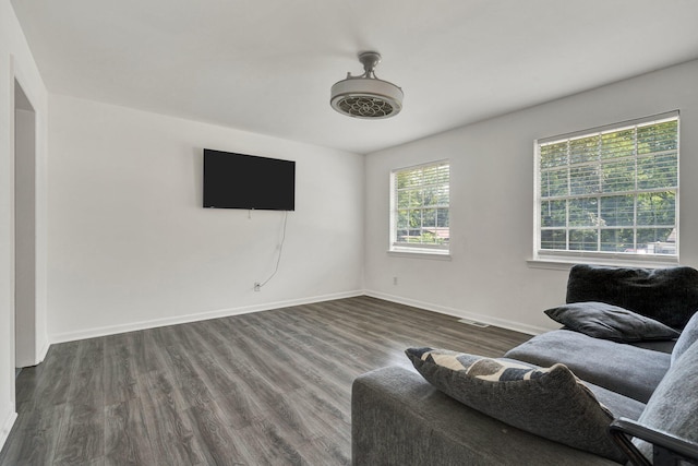 living area featuring baseboards, dark wood-type flooring, and visible vents
