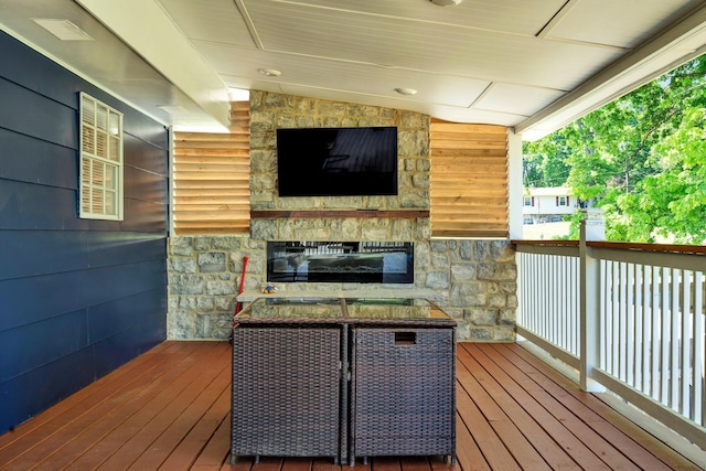 wooden terrace featuring a stone fireplace
