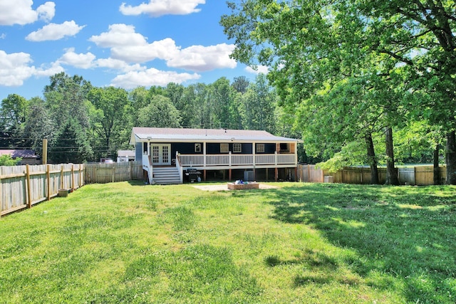rear view of property featuring a yard, french doors, a fenced backyard, and a wooden deck