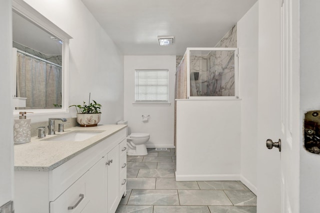 bathroom with a marble finish shower, baseboards, vanity, and toilet