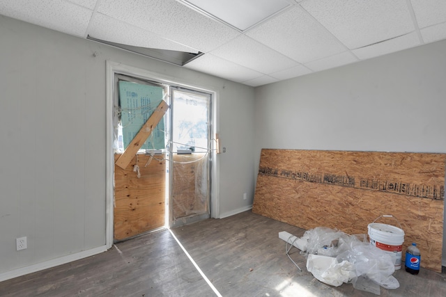 spare room with a paneled ceiling and dark wood-type flooring