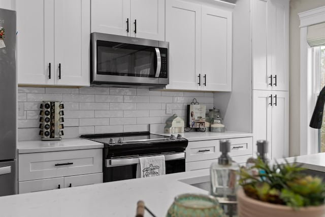 3914 Dogwood Valley Rd, Tunnel Hill, GA 30755 - kitchen with decorative backsplash, white cabinetry, and appliances with stainless steel finishes