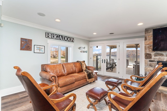 living room with french doors, ornamental molding, a fireplace, and hardwood / wood-style floors