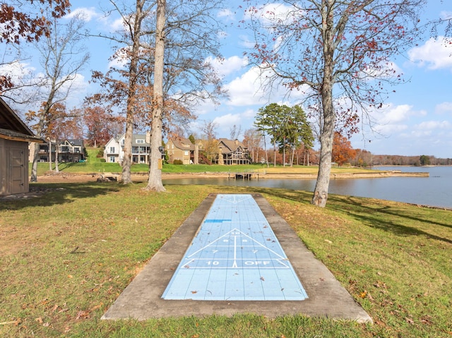 view of home's community with a water view and a yard