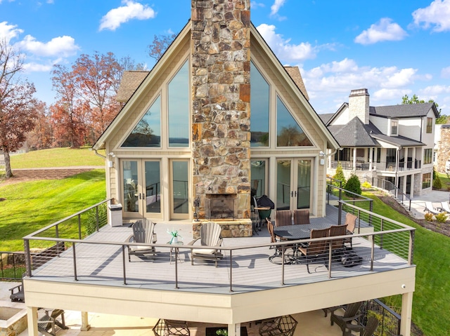 back of house featuring a yard and an outdoor stone fireplace