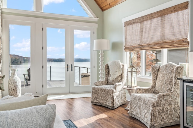 sitting room with a water view, wood-type flooring, french doors, and wooden ceiling