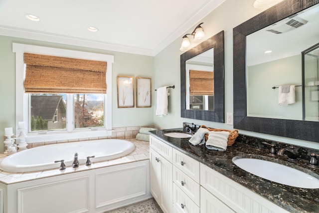 bathroom with vanity, ornamental molding, and a tub