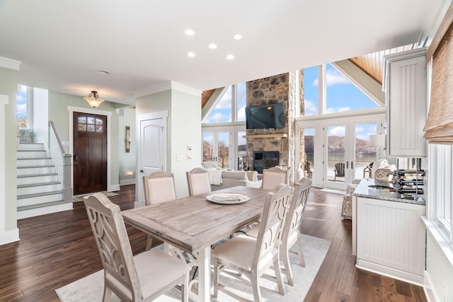 dining room with dark wood-type flooring, a fireplace, and ornamental molding