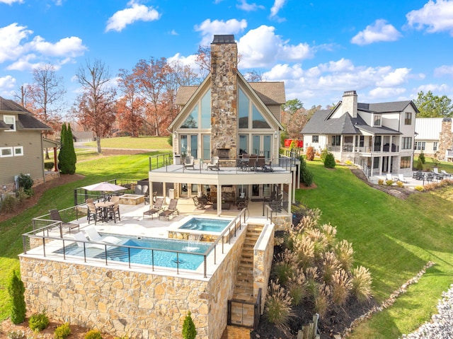 back of house with a pool with hot tub, a yard, a fireplace, and a patio