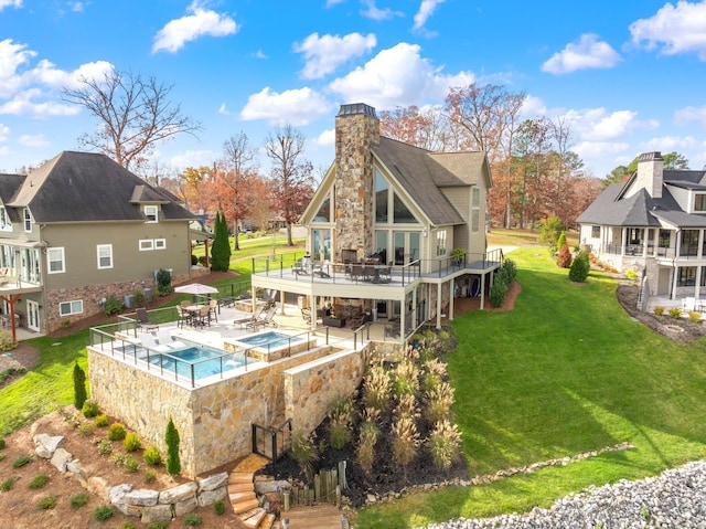 back of property featuring a pool with hot tub, a yard, and a patio