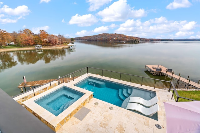 view of pool with a water view and an in ground hot tub