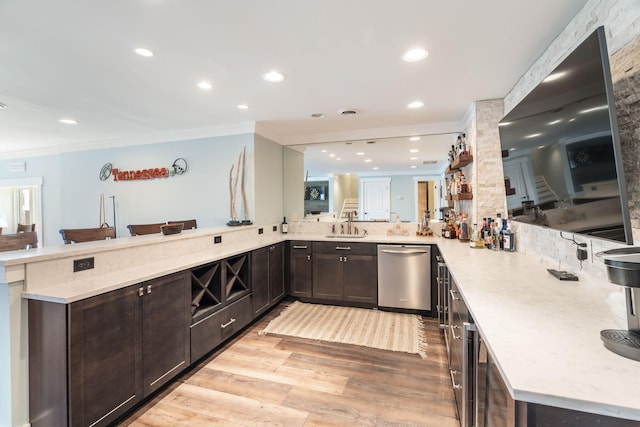 kitchen with stainless steel dishwasher, kitchen peninsula, sink, crown molding, and light hardwood / wood-style flooring