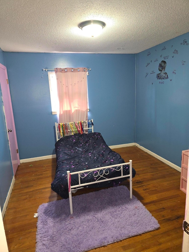 bedroom with dark wood-type flooring and a textured ceiling