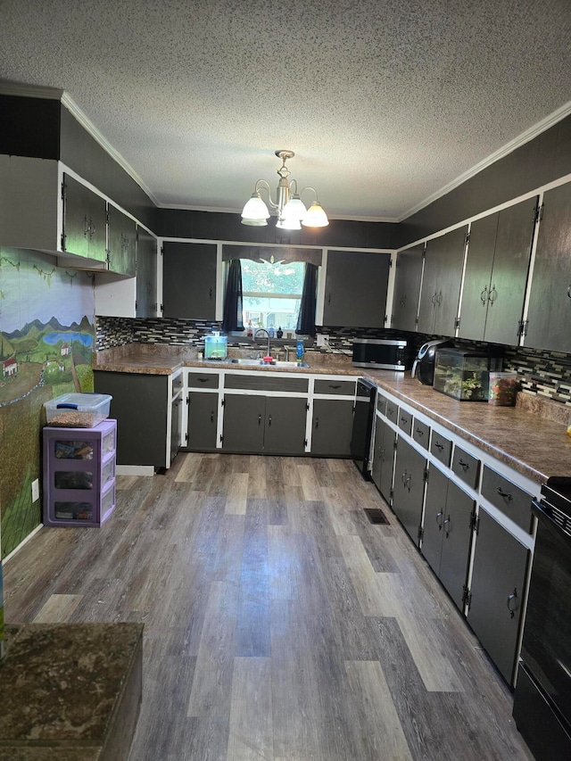 kitchen with electric range, sink, an inviting chandelier, light hardwood / wood-style floors, and decorative light fixtures