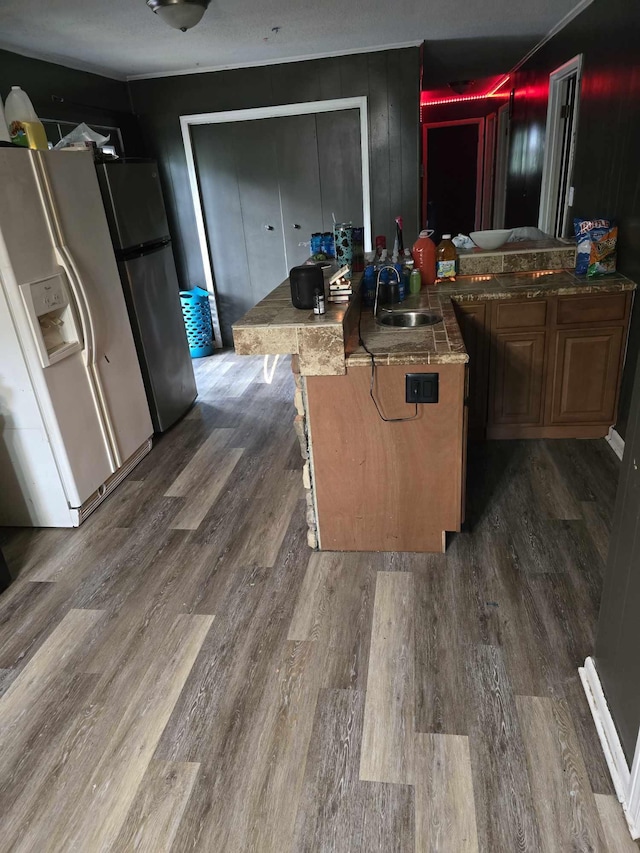 kitchen featuring a kitchen breakfast bar, sink, dark hardwood / wood-style floors, and white refrigerator with ice dispenser