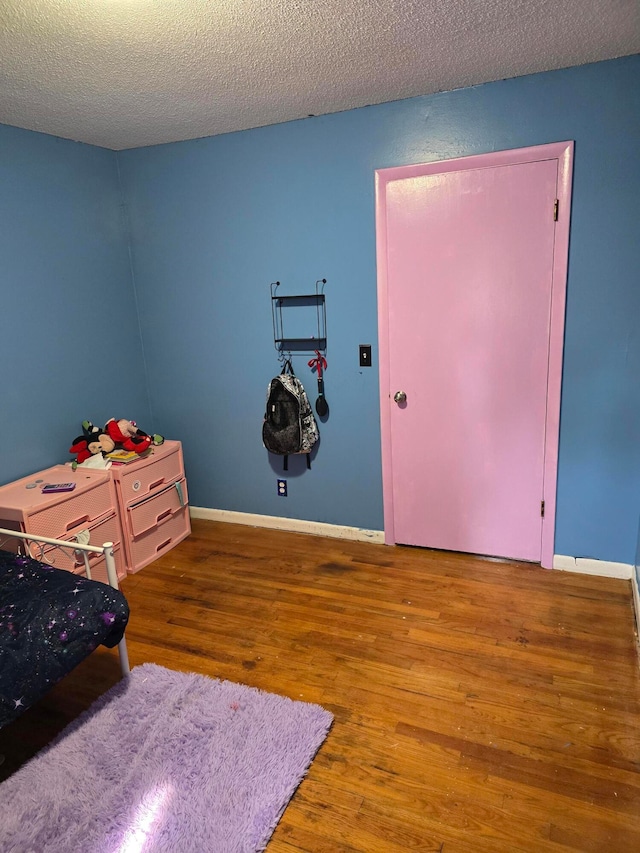 bedroom featuring a textured ceiling and hardwood / wood-style flooring