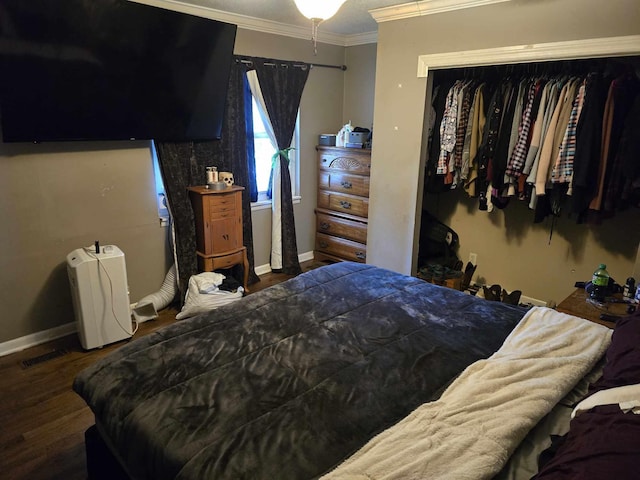 bedroom with dark hardwood / wood-style floors, a closet, and crown molding